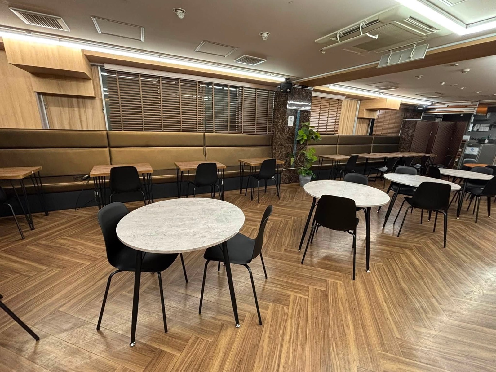 ヘリンボーンの床とやわらかな照明のカフェ空間